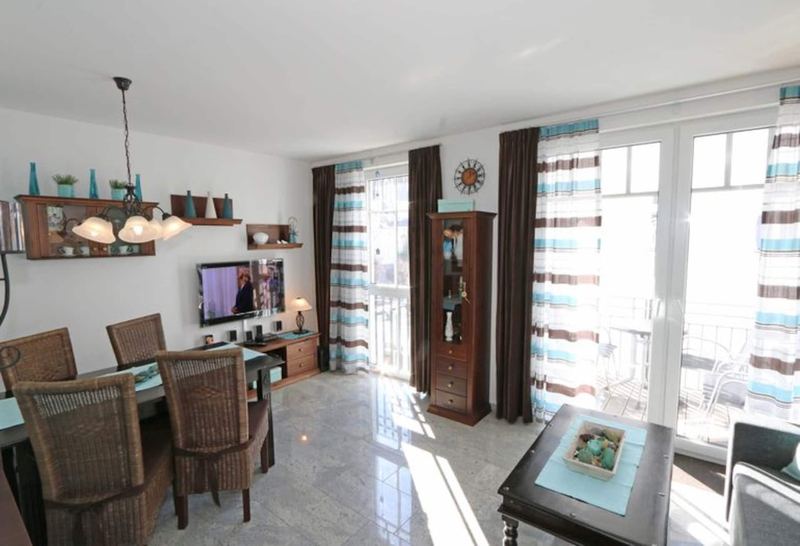 Wohnzimmer mit Esstisch und Zugang zum Südbalkon