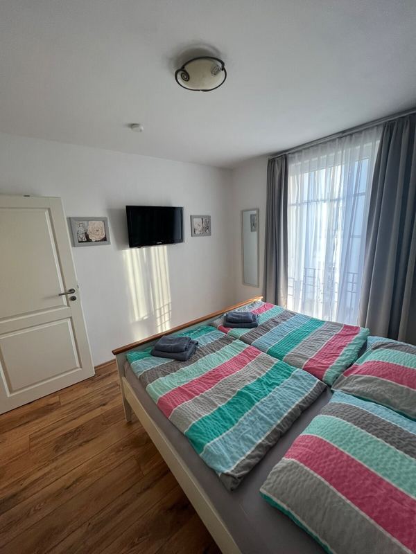 Schlafzimmer mit Fernseher und Blick zum Fenster